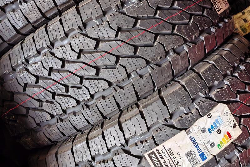 Stack of new Bridgestone Dueler all-terrain tyres with a size label
