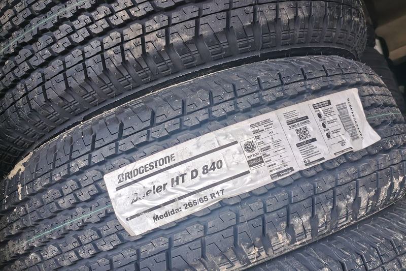Stack of new Bridgestone Dueler H/T tyres with size labels on the tread