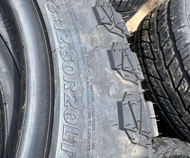 Off-road tyre sidewall marked 33x12.50R20LT with a warning about underinflation and overloading