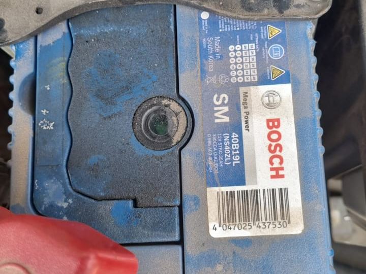 Bosch car battery in an engine bay with its size code and specification label visible